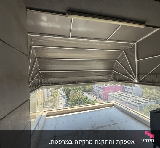 מרפסת עם סוכך מתקפל מעל נוף עירוני